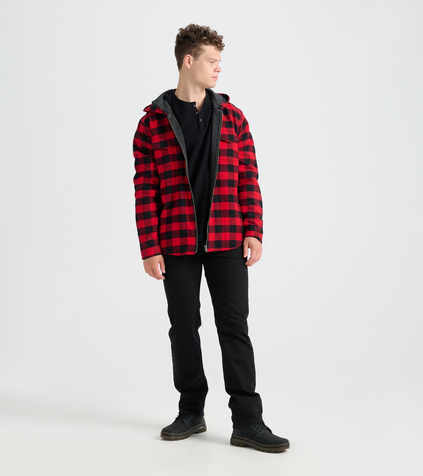 Red and black buffalo plaid flannel jacket with a hood, worn by a model standing sideways.