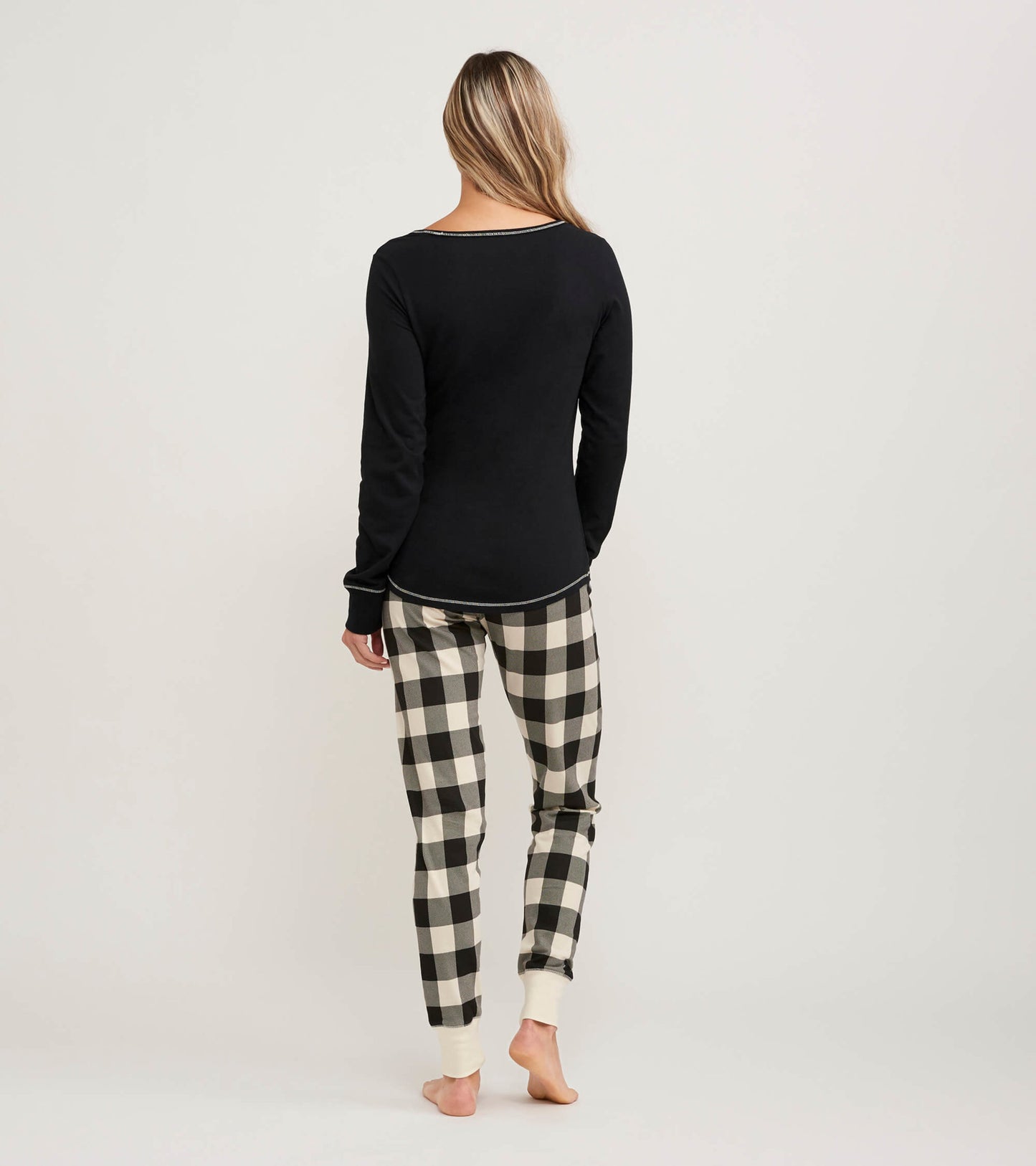 Cream plaid women's sleep leggings with fitted cuffs, shown from the back, paired with a black long-sleeve top.