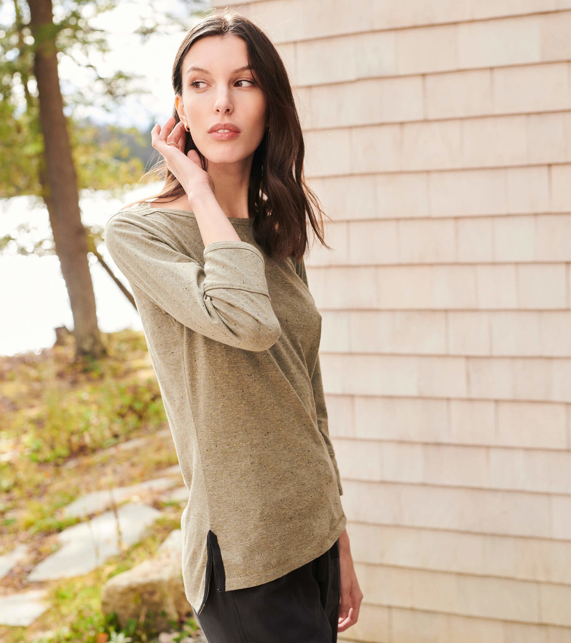 Loden green 3/4 sleeve Breton top with a relaxed fit and side slits, styled casually outdoors.
