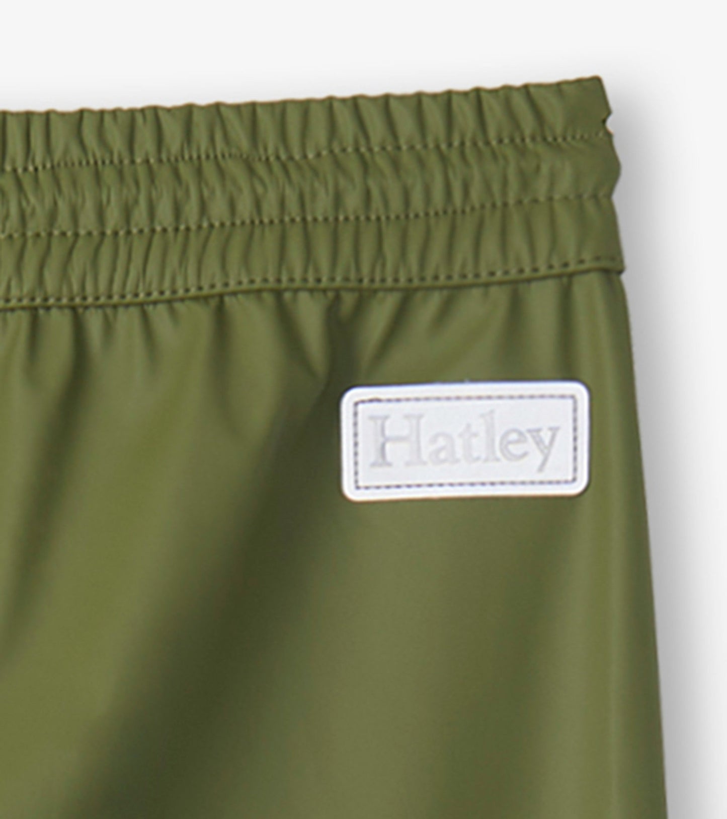 Forest green kids' rain pants with an elastic waistband and a small logo patch. Ideal for wet weather play.