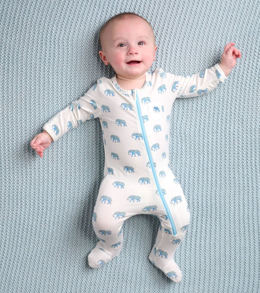 Light-colored baby footed sleeper featuring a playful elephant pattern and a front zipper, suitable for infants.