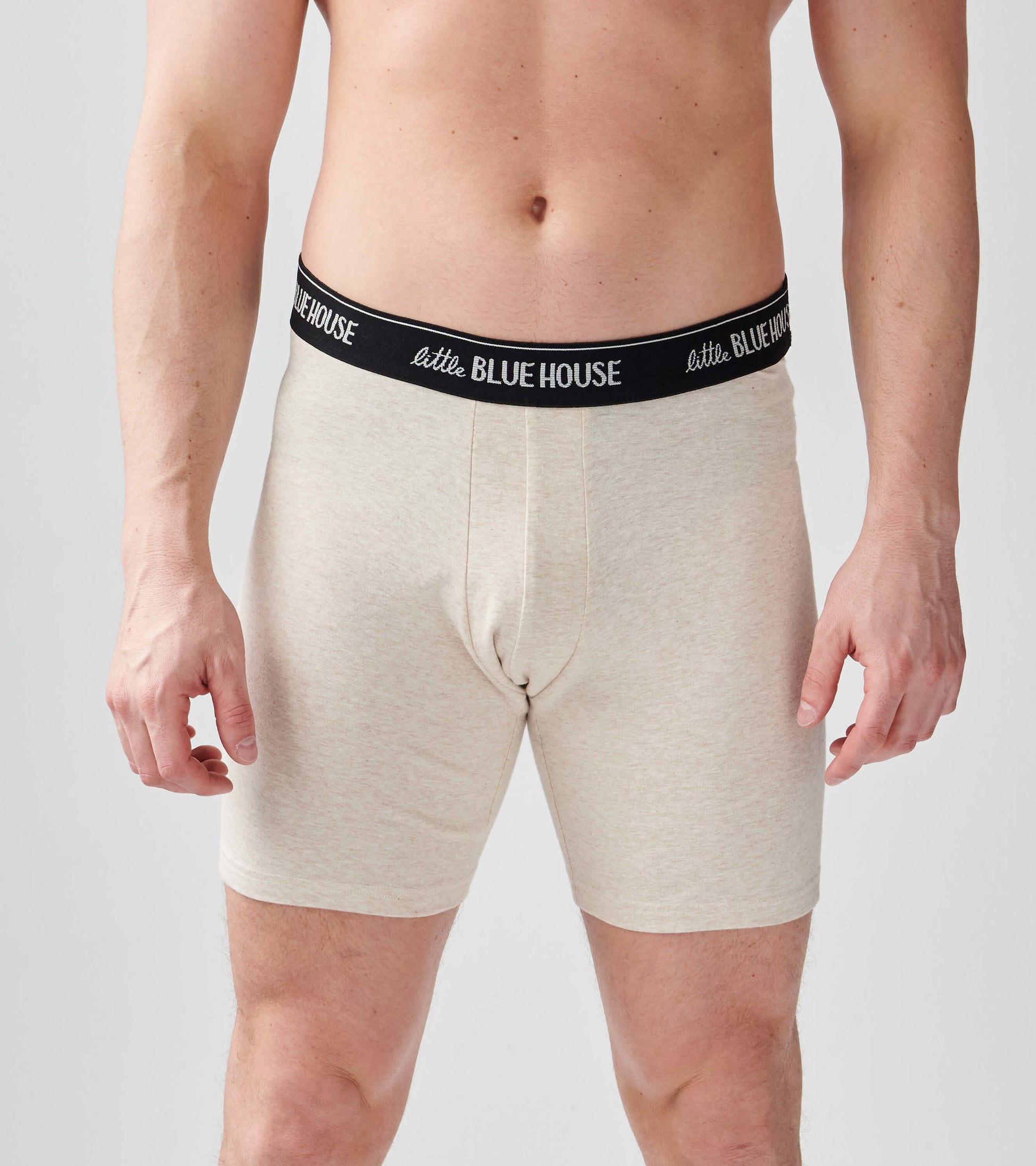 Beige boxer briefs with a black waistband, featuring a snug fit and a smooth fabric texture.