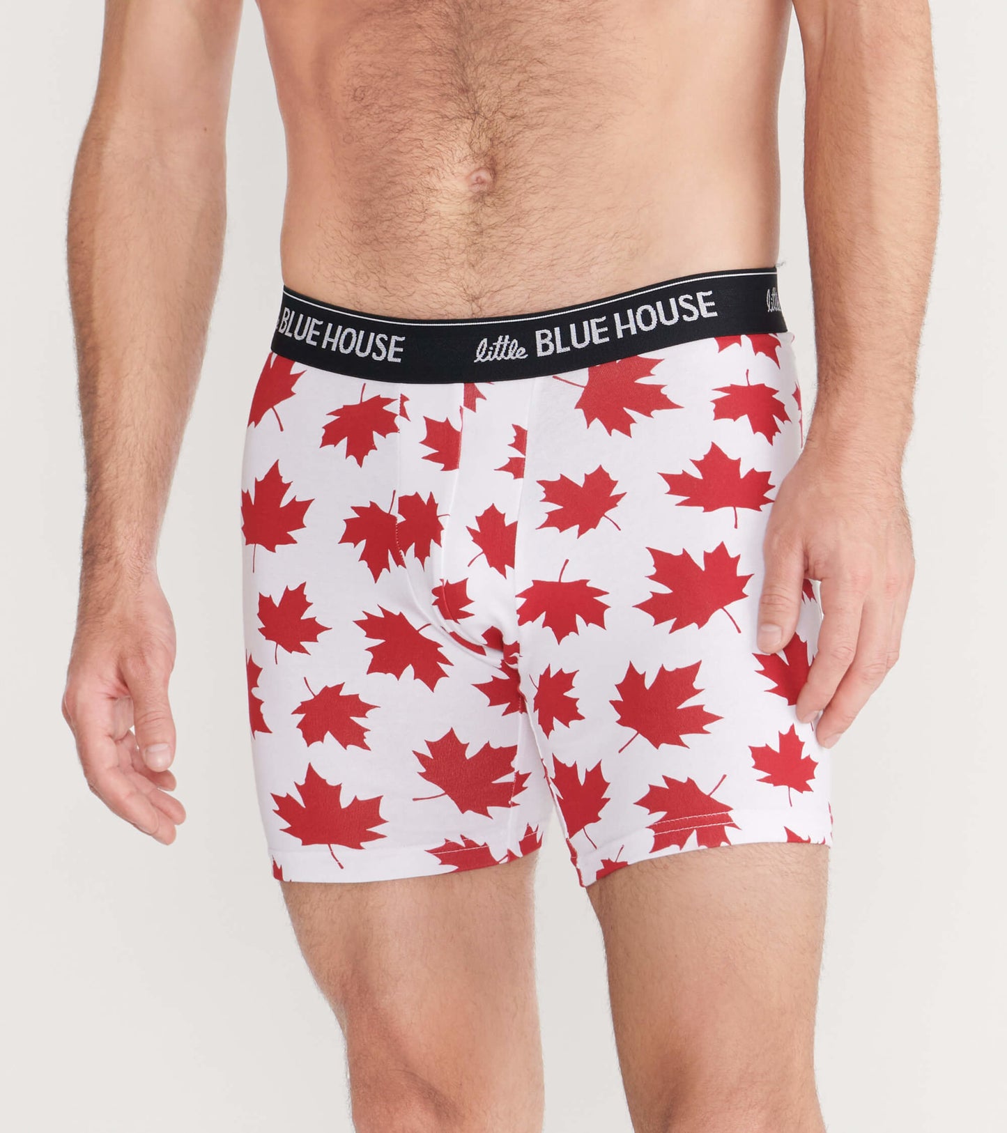 Men's boxer briefs in white with a red maple leaf pattern and a black waistband, shown from the front.