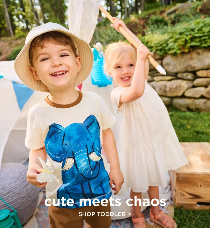 Shop toddler clothing. Showing two toddlers playing outdoors, one wearing a white hat and elephant graphic tee.